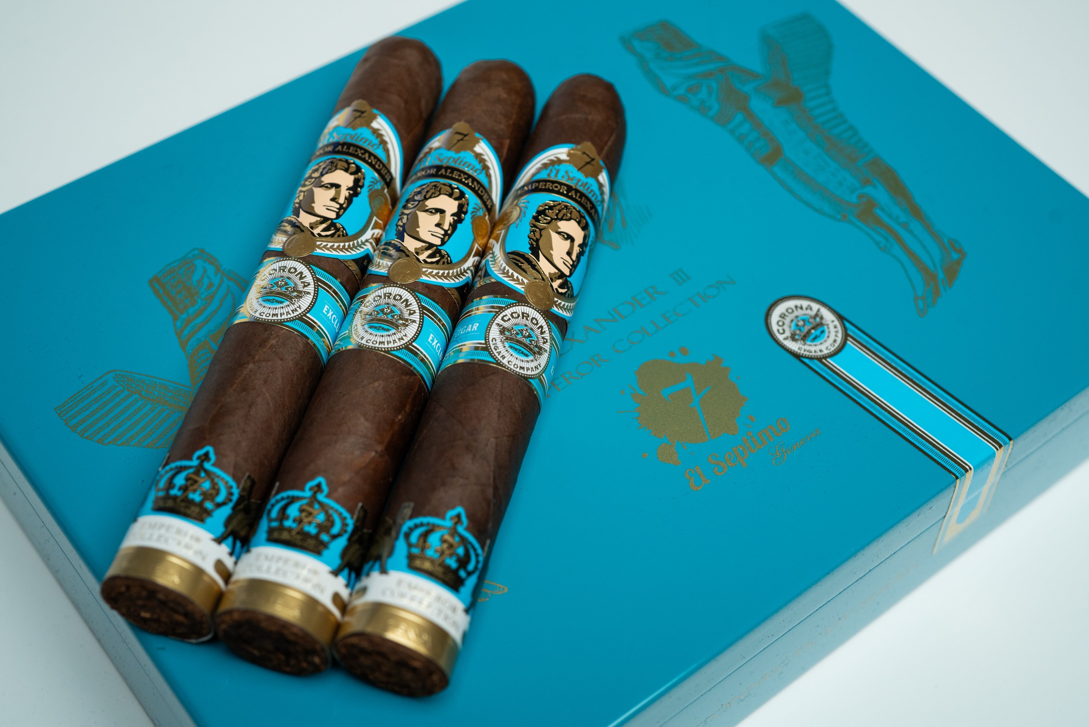 three premium cigars with a blue, gold and black label with an image of emperor alexander on a light blue and gold premium cigar box